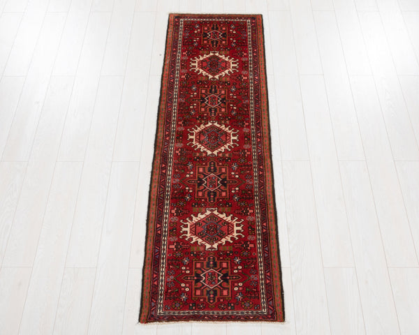 Red patterned rug on a white wooden floor